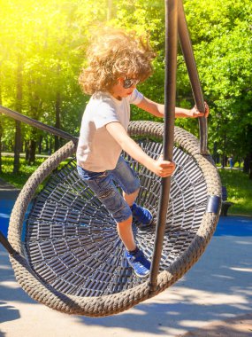 Neşeli çocuk Swing-yuva sallanan. Açık havada okul öncesi için eğlence