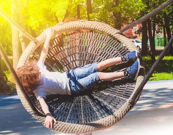 Neşeli çocuk Swing-yuva sallanan. Açık havada okul öncesi için eğlence