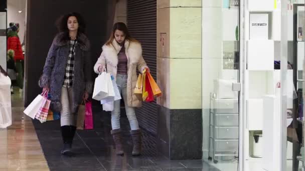 Dos Chicas Ropa Invierno Caminando Centro Comercial Con Bolsas Las — Vídeo de stock