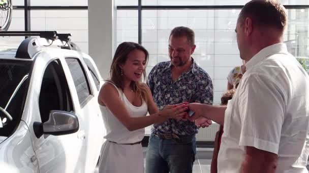 Familia Felicitando Joven Por Conseguir Primer Coche Sala Exposición Coches — Vídeos de Stock