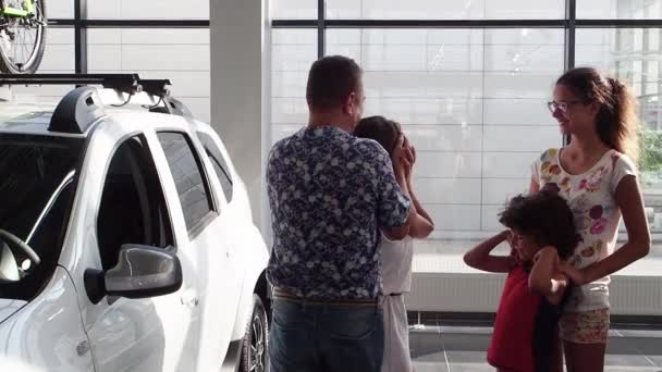 家人祝贺年轻女士得到她的第一辆车在汽车陈列室 慢动作 — 图库视频影像