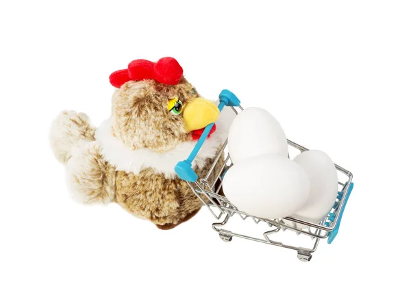 The toy chicken pushes the shopping cart with the pile of eggs. Isolated on white.