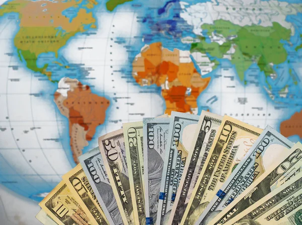 Map of the world covered in money, bank notes of different dollars. Money on the map. Travel concept.