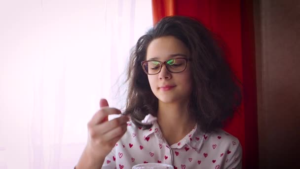窓を覗き込み 懐かしい感じがするメガネをかけた若い可愛い女の子 スローモーション — ストック動画