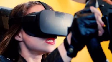 Bir sürüş simülatörü ile bir sanal gerçeklik kulaklık takıyor oyun, video oyun ve bir yarış tekerlek denetleyicisi, teknoloji ve eğlence kavramı kullanarak mutlu kadın