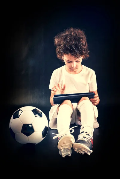 Озадаченный Маленький Мальчик Футболист Футбольным Мячом Используя Планшетный Компьютер Стены — стоковое фото