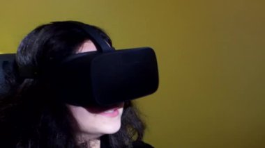 Bir sürüş simülatörü ile bir sanal gerçeklik kulaklık takıyor oyun, video oyun ve bir yarış tekerlek denetleyicisi, teknoloji ve eğlence kavramı kullanarak mutlu kadın