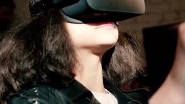 Bir sürüş simülatörü ile bir sanal gerçeklik kulaklık takıyor oyun, video oyun ve bir yarış tekerlek denetleyicisi, teknoloji ve eğlence kavramı kullanarak mutlu kadın