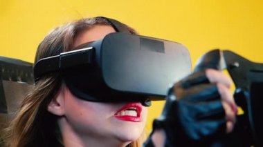 Bir sürüş simülatörü ile bir sanal gerçeklik kulaklık takıyor oyun, video oyun ve bir yarış tekerlek denetleyicisi, teknoloji ve eğlence kavramı kullanarak mutlu kadın