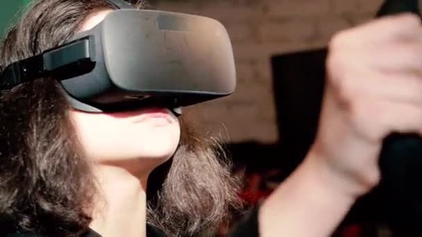 快乐的女人玩驾驶模拟器的视频游戏 她戴着虚拟现实耳机和使用赛车车轮控制器 技术和娱乐的概念 — 图库视频影像