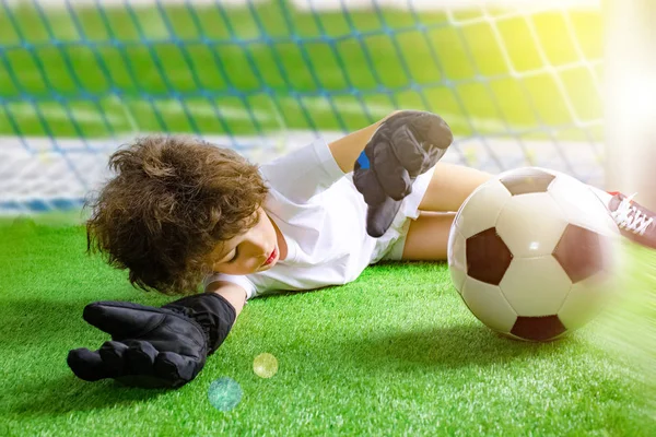 Little soccer goalkeeper in goal. Young soccer goalie attempting to make a save. little soccer goalkeeper with gloves