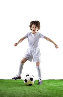 Yeşil çimenlerin üzerinde futbol topu olan çocuk. Heyecanlı küçük yürümeye başlayan çocuk hafif arka plan karşı futbol sahasında futbol oynuyor. Aktif çocukluk ve spor tutku kavramı. Yerden tasarruf edin