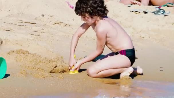 Liten Pojke Leker Med Sand Stranden Dagtid — Stockvideo