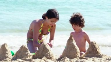 Ablam gündüzleri kumsalda küçük kardeşimle oynuyor. 