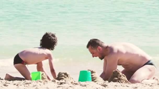 Μπαμπάς Και Γιος Διασκεδάζουν Στην Αμμώδη Παραλία Μέρα — Αρχείο Βίντεο