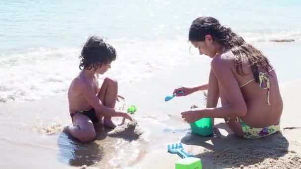 姐姐白天和弟弟在沙滩上玩耍 — 图库视频影像