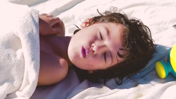 男孩游泳后在海滩上休息的衣服 被毛巾盖住的男孩 — 图库视频影像