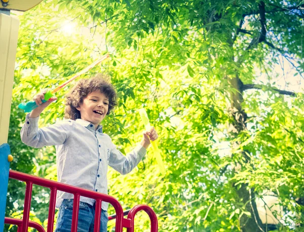 晴れた日に公園で石鹸の泡を吹く少年 — ストック写真