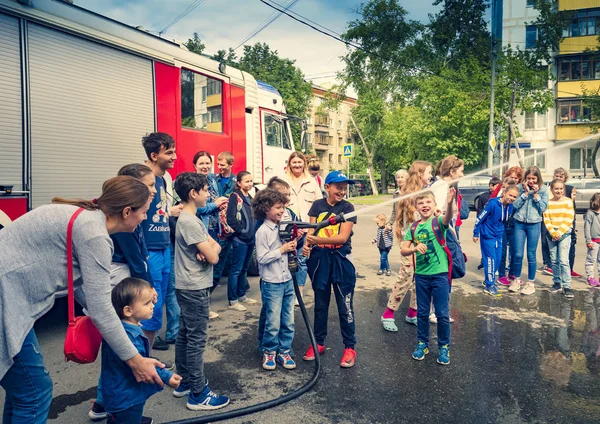 モスクワ ロシア 2019 消防署 消防士のように振る舞う幸せな子供たちは 火のホースのノズルを持ち 水をはねています 消防士を再生する手にホースを持つ子供 — ストック写真