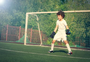 Genç çocuklar için yaz futbol turnuvası. Futbol kulübü. Oyunun heyecanı ve neşesi. Genç kaleci. Çocuk, futbol şampiyonu. Stadyumdaki futbol takımının erkek kalecisi. Spor konsepti.