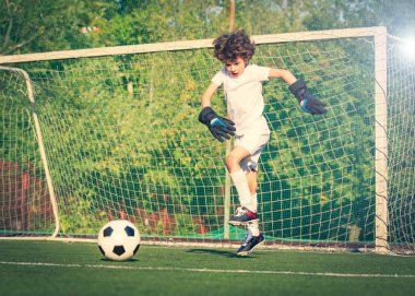 Genç çocuklar için yaz futbol turnuvası. Futbol kulübü. Oyunun heyecanı ve neşesi. Genç kaleci. Stadyumda futbol takımının erkek kalecisi. Spor konsepti. seçici odak
