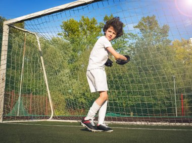 Futbol kapısında genç bir kaleci. Futbol, futbolcu. Çocuk eylem halinde