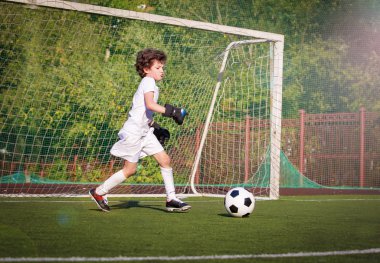 Genç çocuklar için yaz futbol turnuvası. Futbol kulübü. Oyunun heyecanı ve heyecanı. Genç kaleci. Çocuk, futbol şampiyonu. Stadyumda futbol takımının erkek kalecisi. Spor konsepti.