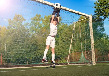 Futbol kapısında genç bir kaleci. Futbol, futbolcu. Çocuk eylem halinde