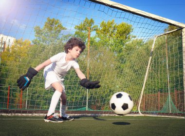 Futbol kapısında genç bir kaleci. Futbol, futbolcu. Çocuk eylem halinde
