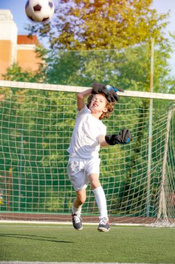 Futbol kapısında genç bir kaleci. Futbol, futbolcu. Çocuk eylem halinde