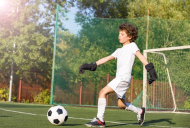 Genç çocuklar için yaz futbol turnuvası. Futbol kulübü. Oyunun heyecanı ve heyecanı. Genç kaleci. Çocuk, futbol şampiyonu. Stadyumda futbol takımının erkek kalecisi. Spor konsepti.