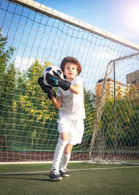 Futbol kapısında genç bir kaleci. Futbol, futbolcu. Çocuk eylem halinde