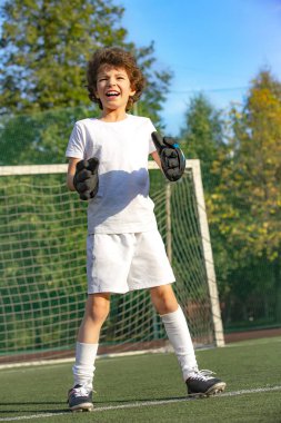 Genç çocuklar için yaz futbol turnuvası. Futbol kulübü. Oyunun heyecanı ve neşesi. Genç kaleci. Çocuk, futbol şampiyonu. Stadyumdaki futbol takımının erkek kalecisi. Spor konsepti.