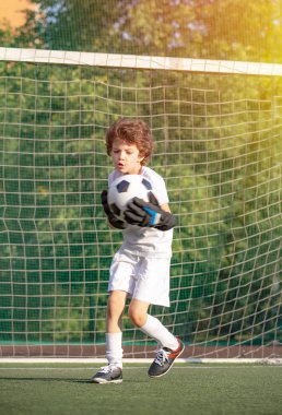 Çocuk futbol maçında gol. Çocuk, futbol şampiyonu. Stadyumda futbol takımının erkek kalecisi. Spor konsepti. Futbolcu çocuk iş başında..