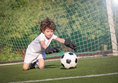 Genç çocuklar için yaz futbol turnuvası. Futbol kulübü. Oyunun heyecanı ve heyecanı. Genç kaleci. Çocuk, futbol şampiyonu. Stadyumda futbol takımının erkek kalecisi. Spor konsepti.