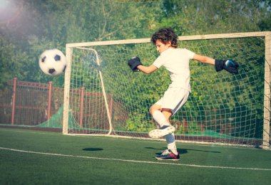 Genç çocuklar için yaz futbol turnuvası. Futbol kulübü. Oyunun heyecanı ve neşesi. Genç kaleci. Stadyumda futbol takımının erkek kalecisi. Spor konsepti. seçici odak