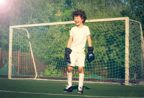 Summer soccer tournament for young kid. football club. emotions and joy of the game. Young goalie. Kid - soccer champion. Boy goalkeeper in football sportswear on stadium. Sport concept.