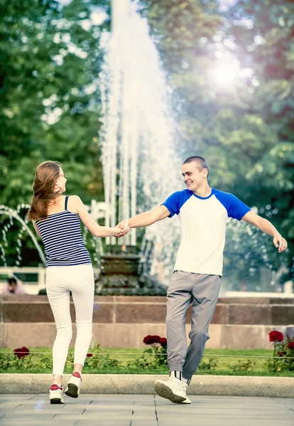 Smiling couple having fun in background of city park. Holidays, vacation, love and friendship concept