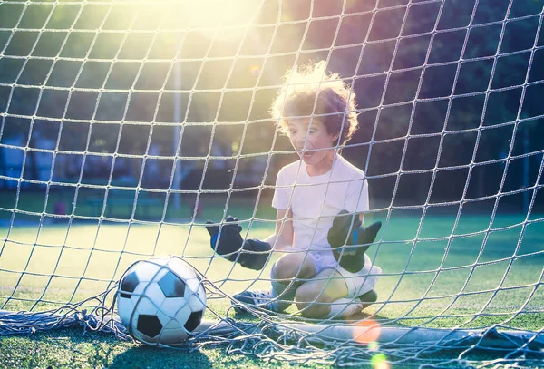 Disappointed football team goalkeeper following goals. Goalkeeper emotionally reacts after missed goal during game. Defeat Concept