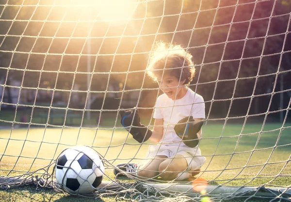 Disappointed football team goalkeeper following goals. Goalkeeper emotionally reacts after missed goal during game. Defeat Concept