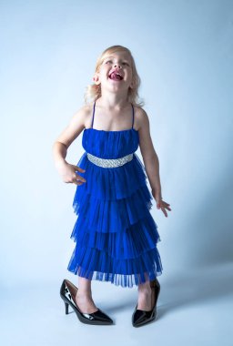 Moda mavisi elbiseli, büyük annelerin giydiği, renkli topuklu ayakkabı giyen, heyecanlı küçük prenses. Heyecan konsepti. Metin modeli için boş alan