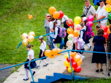 Moskova, Rusya - 3 Eylül 2018: lise öğrencileri ve birinci sınıf öğrencileri bilgi gününde ana okul hattında açık hava cetveli üzerinde duruyorlar