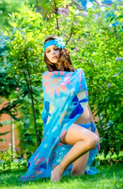 Yeşil çimlerin ve ormanın arka planında mayo giymiş manken görünümlü bir kız..