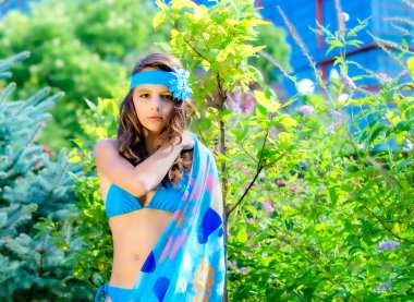 Yeşil çim ve ormanın arka planında mayo giymiş manken görünümlü bir kız. Boşluğu kopyala