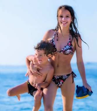 Kız ve erkek kardeş gün içinde plajda oynuyorlar. Kardeşini ve kardeşini sonsuza dek kavra.