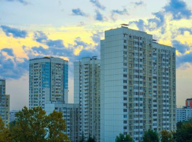 Moskova, Rusya 30 Ağustos 2018: Akşam gökyüzü ile güzel şehir manzarası, parlak güneş çok katlı binalar arasındaki bulutların arasından doğuyor.