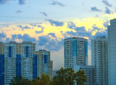 Moskova, Rusya 30 Ağustos 2018: Akşam gökyüzü ile güzel şehir manzarası, parlak güneş çok katlı binalar arasındaki bulutların arasından doğuyor.