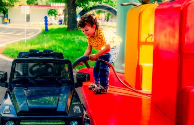 Lunapark, havalı çocuk benzin istasyonunda oyuncak araba çalıştırıyor.