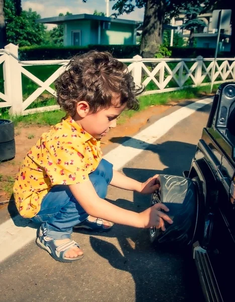 Junge Beim Reifenwechsel Einem Schwarzen Spielzeugauto Kinder Städtischen Freizeitpark — Stockfoto