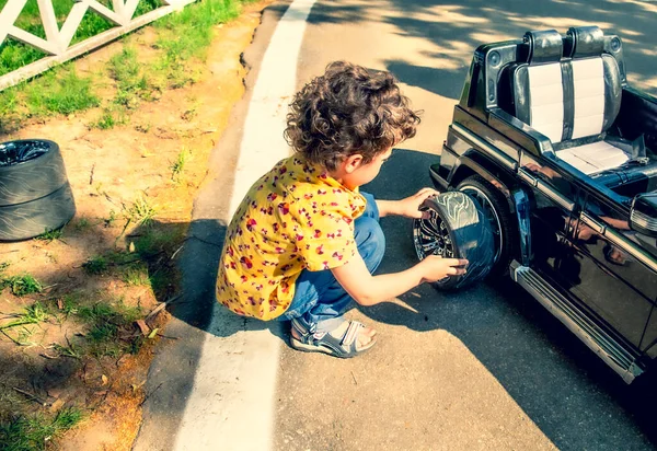 Jongen Die Een Band Verwisselt Een Zwarte Speelgoedauto Kinderen Het — Stockfoto